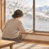 冬の窓の結露を布で拭き取る様子