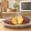 電子レンジのある台所で皿に載せたさつまいも